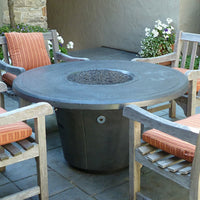 Cosmopolitan 48 inch round concrete fire pit table by American Fyre Designs in outdoor backyard setting