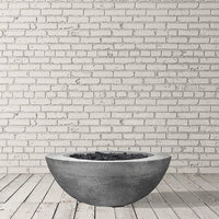 Moderno VI round concrete fire pit table with glowing flames on a patio