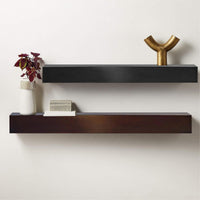 Custom steel mantel shelves in black and brown finishes with minimalist decor on a white wall