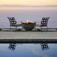 Moderno I Bowl 39-inch round concrete fire pit table by Prism Hardscapes in outdoor patio setting