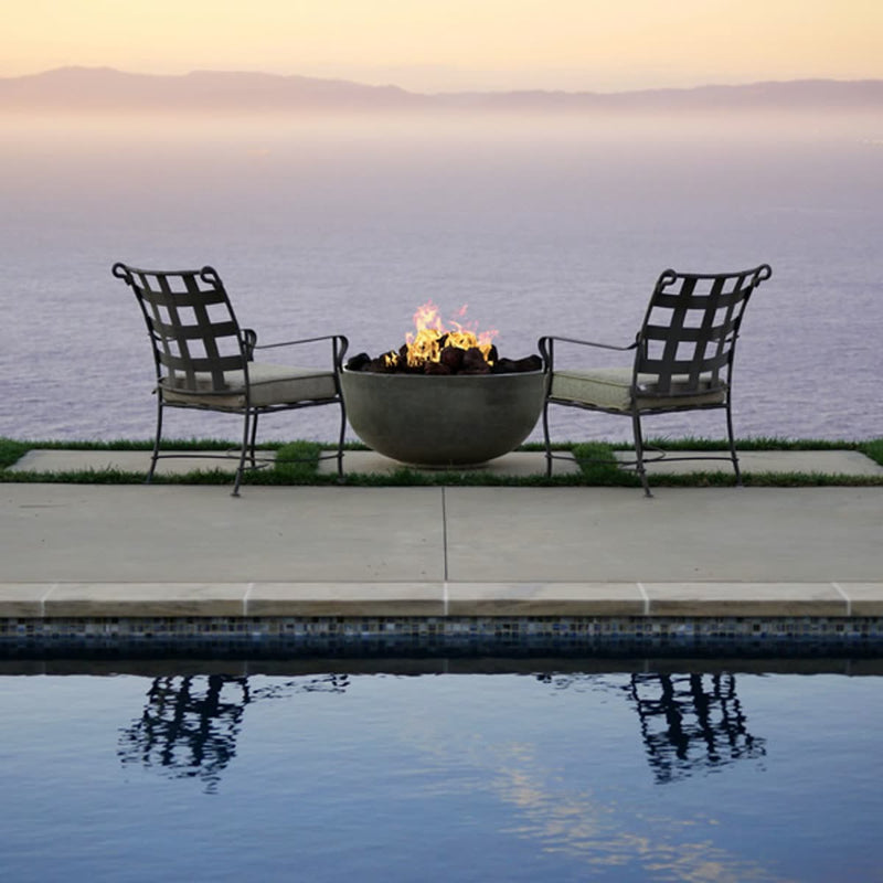 Moderno I Bowl 39-inch round concrete fire pit table by Prism Hardscapes in outdoor patio setting