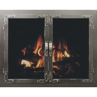 Rustic masonry fireplace glass door with distressed metal and riveted corners