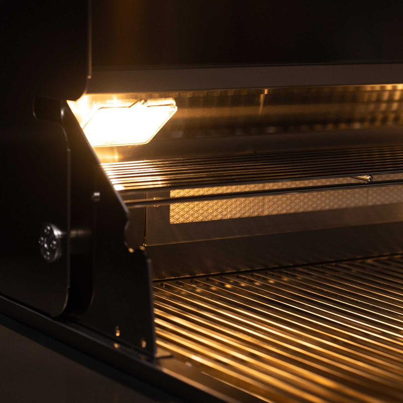Close-up of the TrueFlame 40 inch built-in stainless steel grill interior with halogen lighting and cooking grates.