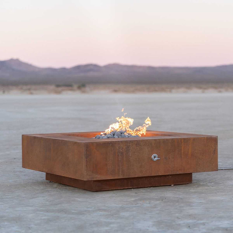 Cabo Square Corten Steel Fire Pit with lava rocks burning in outdoor desert setting