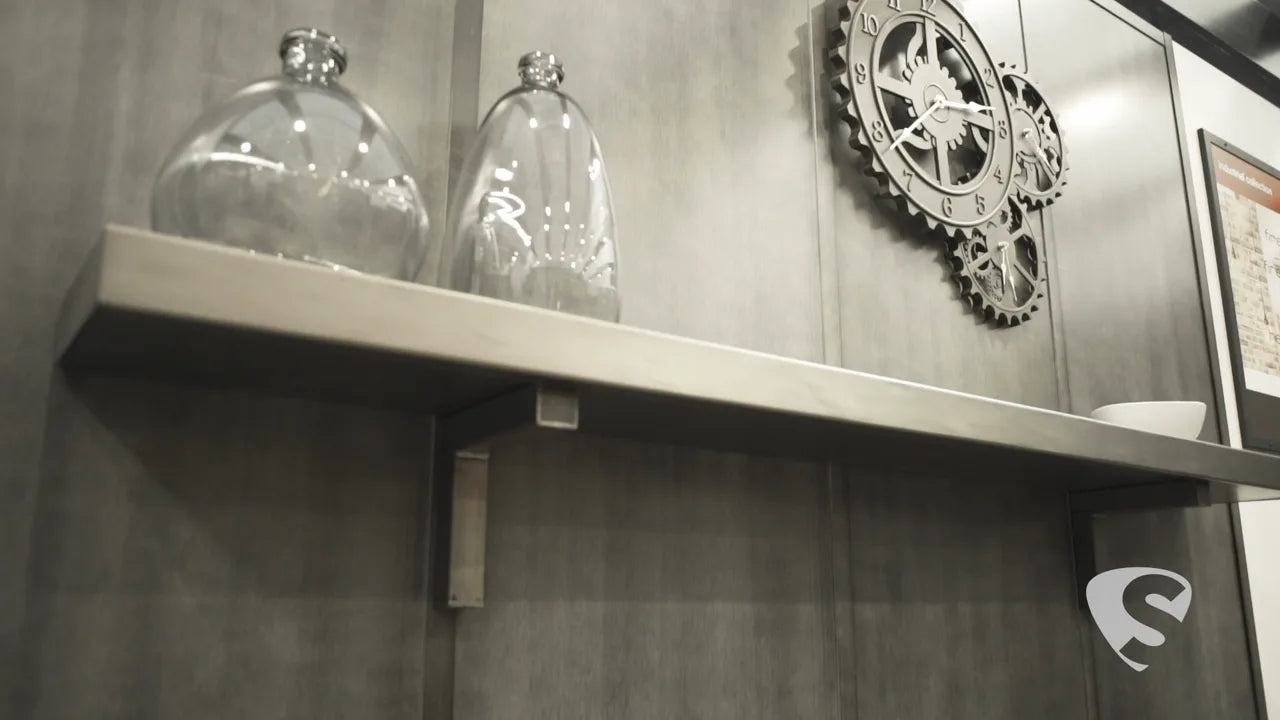A custom steel floating mantel shelf on a grey wall, with glass jars on top.