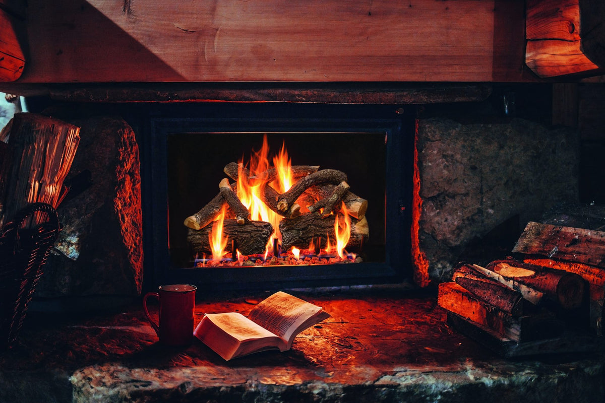 Burning Arizona Weathered Oak Charred gas logs in a rustic stone fireplace