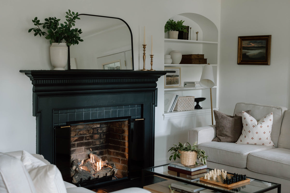 Dark fireplace surround and glass doors in a furnished living room
